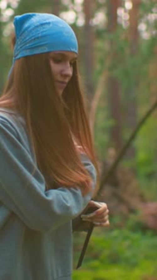 Lady Playfully Drops Bag on Grassy Ground in Scenic Forest