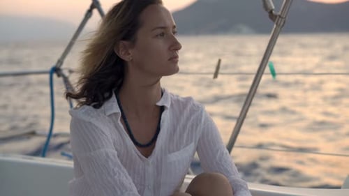 Pensive, Young Woman Sailing Boat On Sea During Sunset