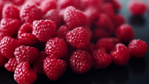 Scattering of Fresh Bright Raspberry Slowly Spinning Close Up