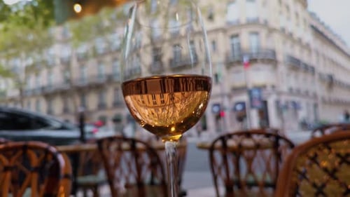 Glistening Wine Glass Reflecting City View in a Cozy Cafe Setting