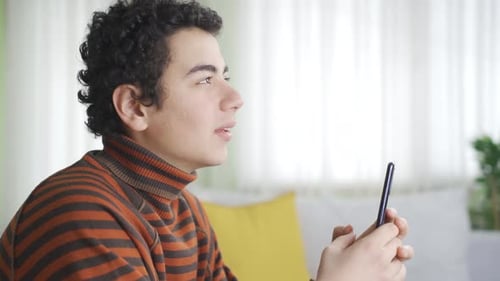 Teen Talking on Smartphone Video Call Indoors