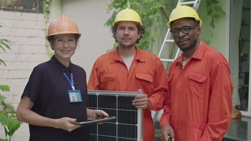 Portrait of Female Engineer and Workers with Solar Panel Outdoors
