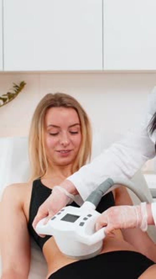 Woman Receiving LPG Vacuum Massage on Belly Area By Cosmetologist Using Modern Equipment in Clinic