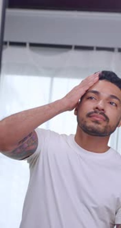 Man Styles Hair and Beard in Close Up