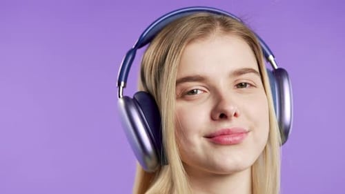 Blonde Young Woman Listening Music with Headphonesviolet Studiowireless Player