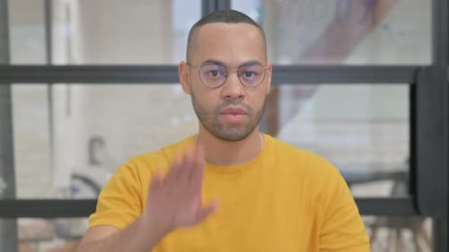 Man with Eyeglasses Gives Stop Hand Gesture