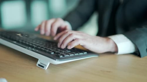 hands close up of business man in office typing on keyboard. male, employee, entrepreneur in a suit
