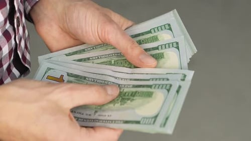 Hands Count Stack of One Hundred Dollar Bills