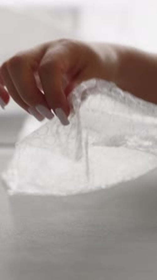 Woman Popping Bubble Wrap with Manicured Hands