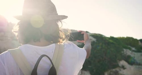 Beautiful young girl doing selfie at the sea, smiling waving at the camera, in a swimsuit in a str