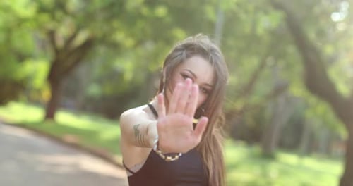 Woman Hand Gesture Stop, Push Away in Sunny Park