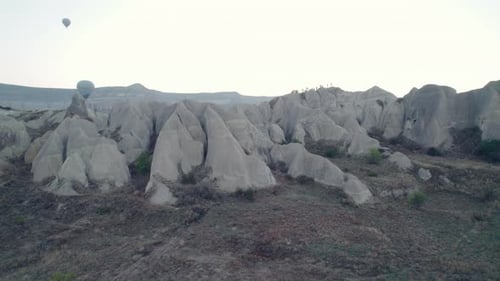 Hot air balloons over unique rock formations at sunrise in Cappadocia