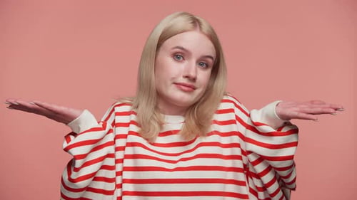 Woman Shrugging in Confusion or Uncertainty on Pink Background