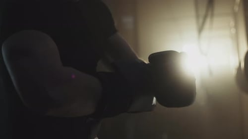 Athlete Putting On Boxing Gloves in Gym