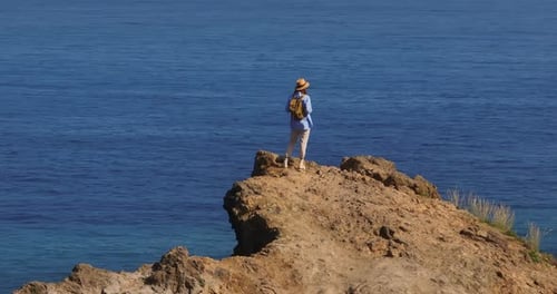 A Traveler Walks on a Paradise Island Active Young Woman Climbs on Top of Cliff for a View in Hiking