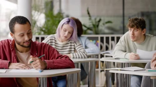 Zeitlupe junger Schüler, die während einer Schulprüfung einen Test eines Klassenkameraden abschreiben
