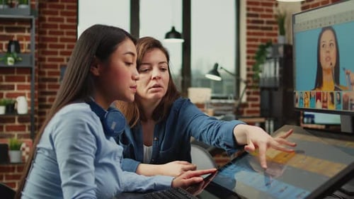 Two Women Editing Video on Touchscreen Monitor
