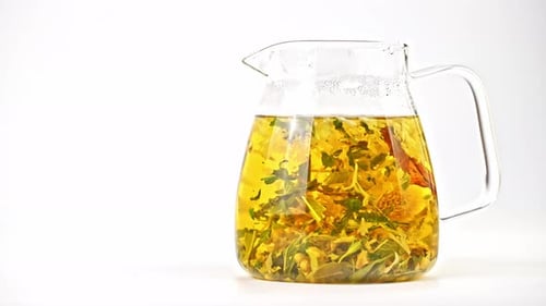 Herbal Tea Infusion in Glass Pitcher on White