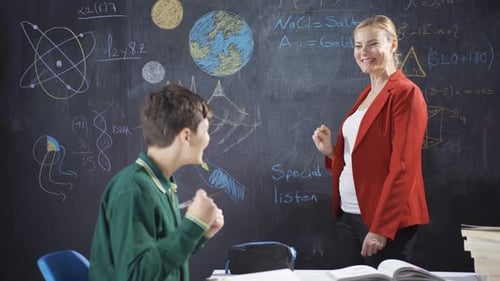 Teacher Explains Lesson to a Student in Classroom