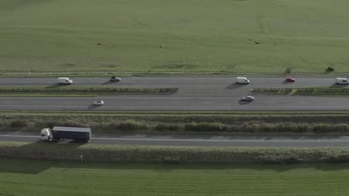 Six traffic lanes on highway aerial with green pasture on both sides