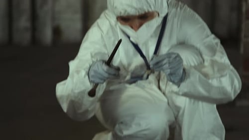 Forensic Investigator Collecting Evidence at Crime Scene