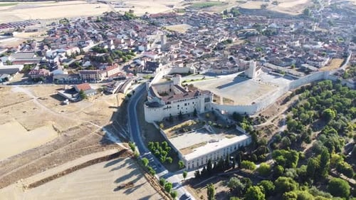 aerial view daylight medieval castle or palace with long walls, garden and traditional old town.