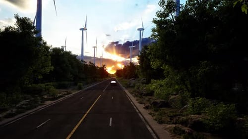 3D render of generic electric car drives on a Road with wind turbines in the background