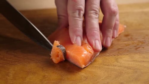 Slicing Fresh Raw Salmon on Cutting Board