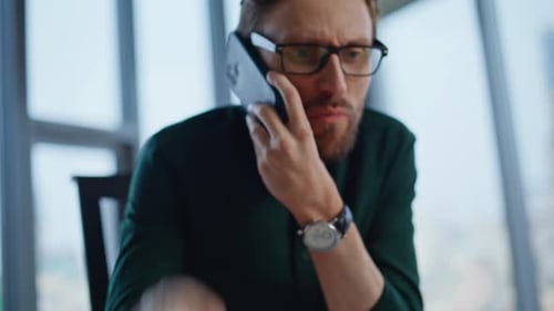 Angry Manager Pointing Notebook Calling Cellphone in Modern Office Closeup