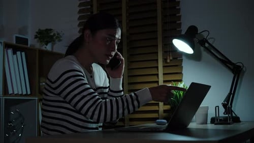 Woman Working Late at Desk on Computer and Phone