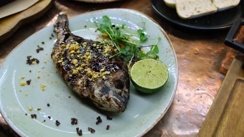 Grilled Fish Garnished with Lime and Greens
