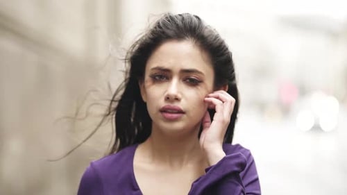 Sad Woman Touches Her Face in City