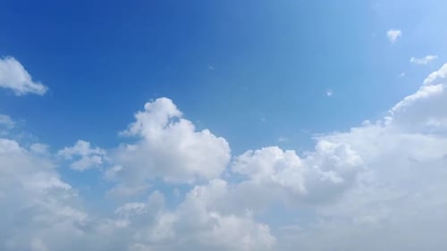 Fluffy White Clouds Floating Across the Blue Sky