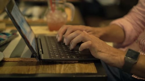 Man Working on Laptop Sitting in Cafe 30s