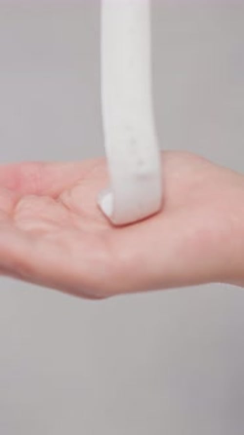 White Rubber Band Coiling Around Hand, Close Up