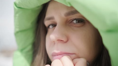 A Young Woman Reflects Thoughtfully While Enjoying a Snowy Winter Afternoon in a Quiet Park Setting