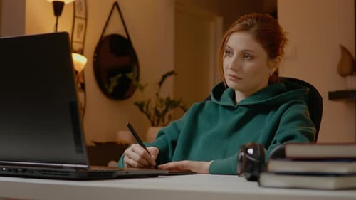 Graphic designer working from home using laptop and tablet