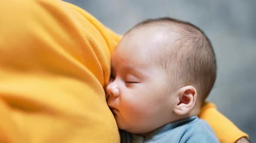 Sleeping Infant Resting Peacefully on Adult's Chest