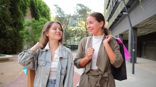 Two Cheerful Friends Enjoying a Delightful Shopping Experience While Engaging in Friendly