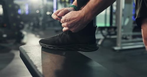 Hands, shoes and tie laces in gym for fitness, run or start exercise routine with man for health