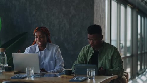 Business Meeting in a Cafe Two Black Employees are Discussing a Business Plan Looking and Discussing