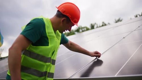 Engineer Inspecting Solar Panels at Renewable Energy Station