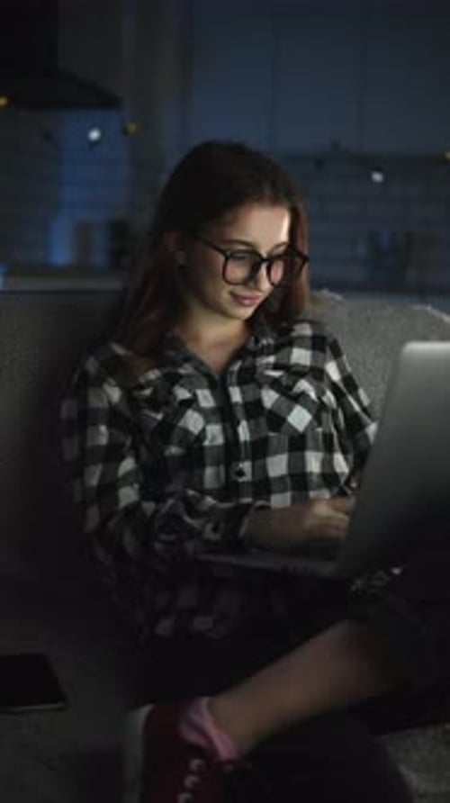 Woman Working on Laptop at Night at Home
