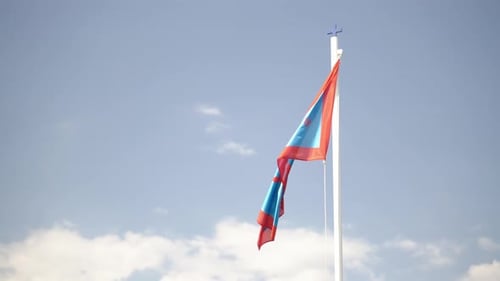 Waving Red and Blue Flag Against Blue Sky