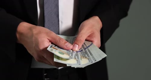 Man Counting Stack of Hundred Dollar Bills