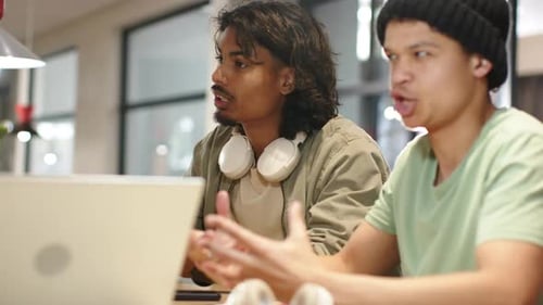 Des hommes afro-américains collaborent à une table, le bon homme tapant sur un ordinateur portable puis expliquant les résultats