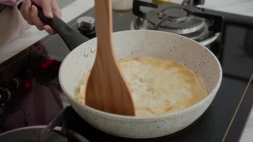 Person Cooking Egg on a Stove Top