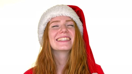 Static medium close-up shot of a cute redhead lady wearing a Santa hat and smiling