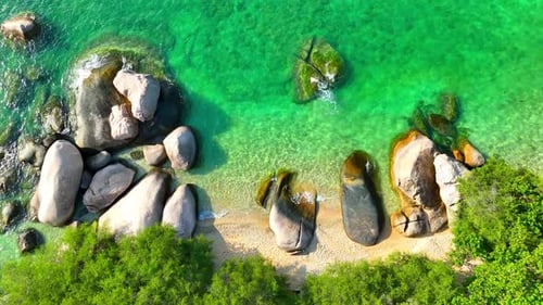 Stunning sandy beach with rock, clean sea water and green forest. 4K.