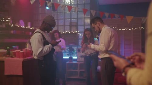 Friends Socializing at a Party While Using Phones